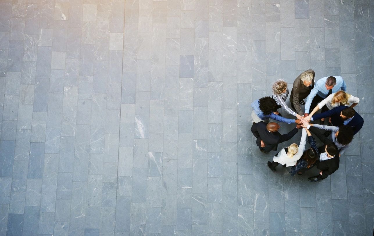 Business team joining hands overhead view